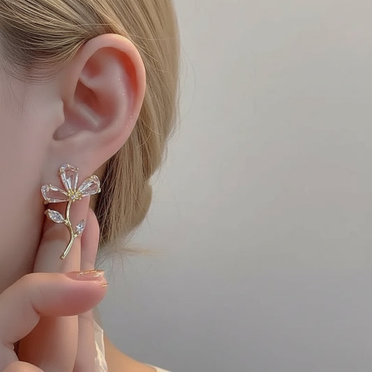 Woman wearing gold CZ branch earrings close-up