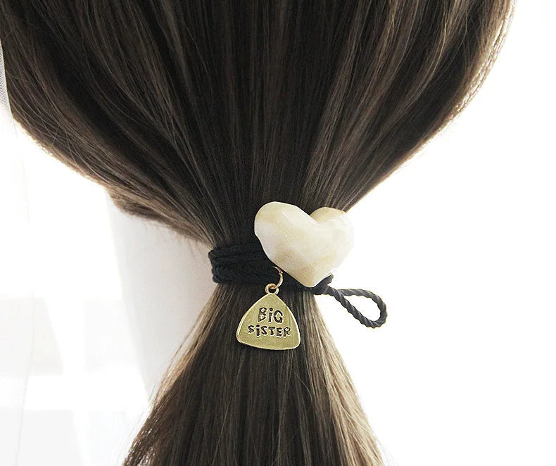 Decorative elastic hair bands for women featuring rhinestones, bows, pearls and alloy charms, styled for ponytails and daily fashion use. 