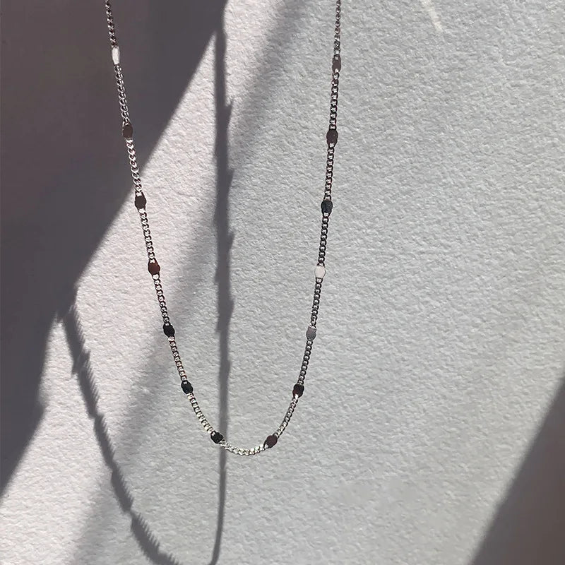 Dainty sterling silver clavicle chain photographed in sunlight