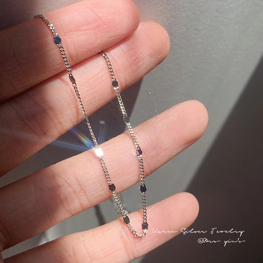 Close-up of 925 sterling silver minimalist chain necklace in hand