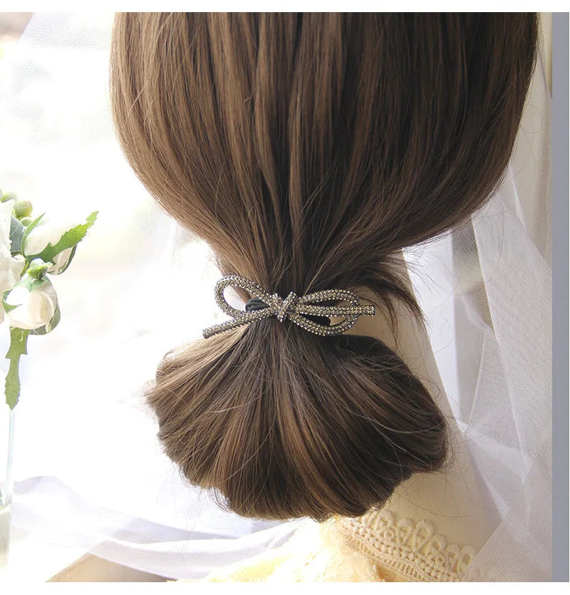 Decorative elastic hair bands for women featuring rhinestones, bows, pearls and alloy charms, styled for ponytails and daily fashion use. 