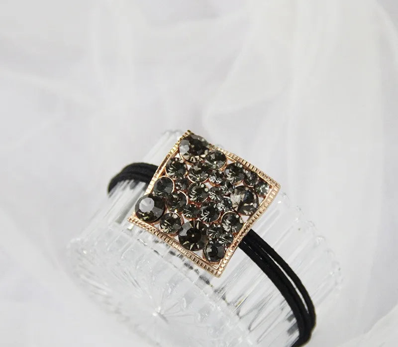 Decorative elastic hair bands for women featuring rhinestones, bows, pearls and alloy charms, styled for ponytails and daily fashion use.