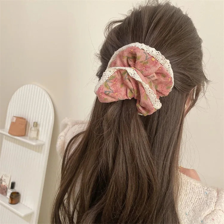 Corduroy scrunchie with floral pattern and lace edges used in half-up hairstyle.