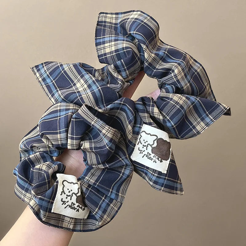 Plaid polyester scrunchie with elastic rubber core, vintage square-check hair accessory.