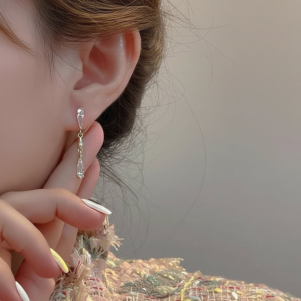 Woman wearing dangling gold crystal branch earrings